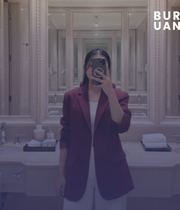 Cerpenis Buruan.co, Erniati Efendi, berfose di depan cermin menggunakan blazer merah.