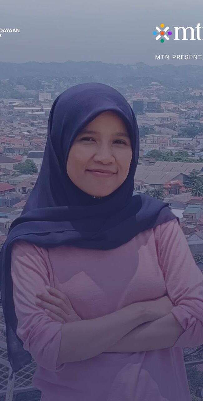 Cerita Pendek SZ Nufus di Buruan.co. Nufus menggunakan kerudung biru tua, kaos pink panjang, berdiri memangku tangan.